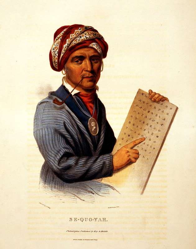 Sequoyah depicted holding a tablet with his syllabary and pointing at it.